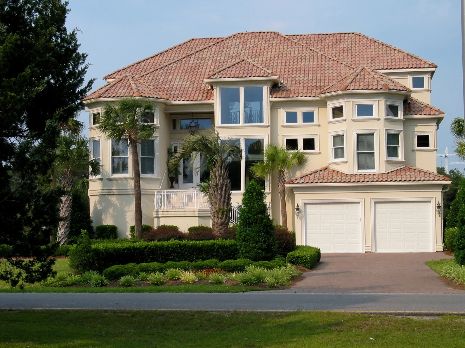 A large house with a driveway and bushes.