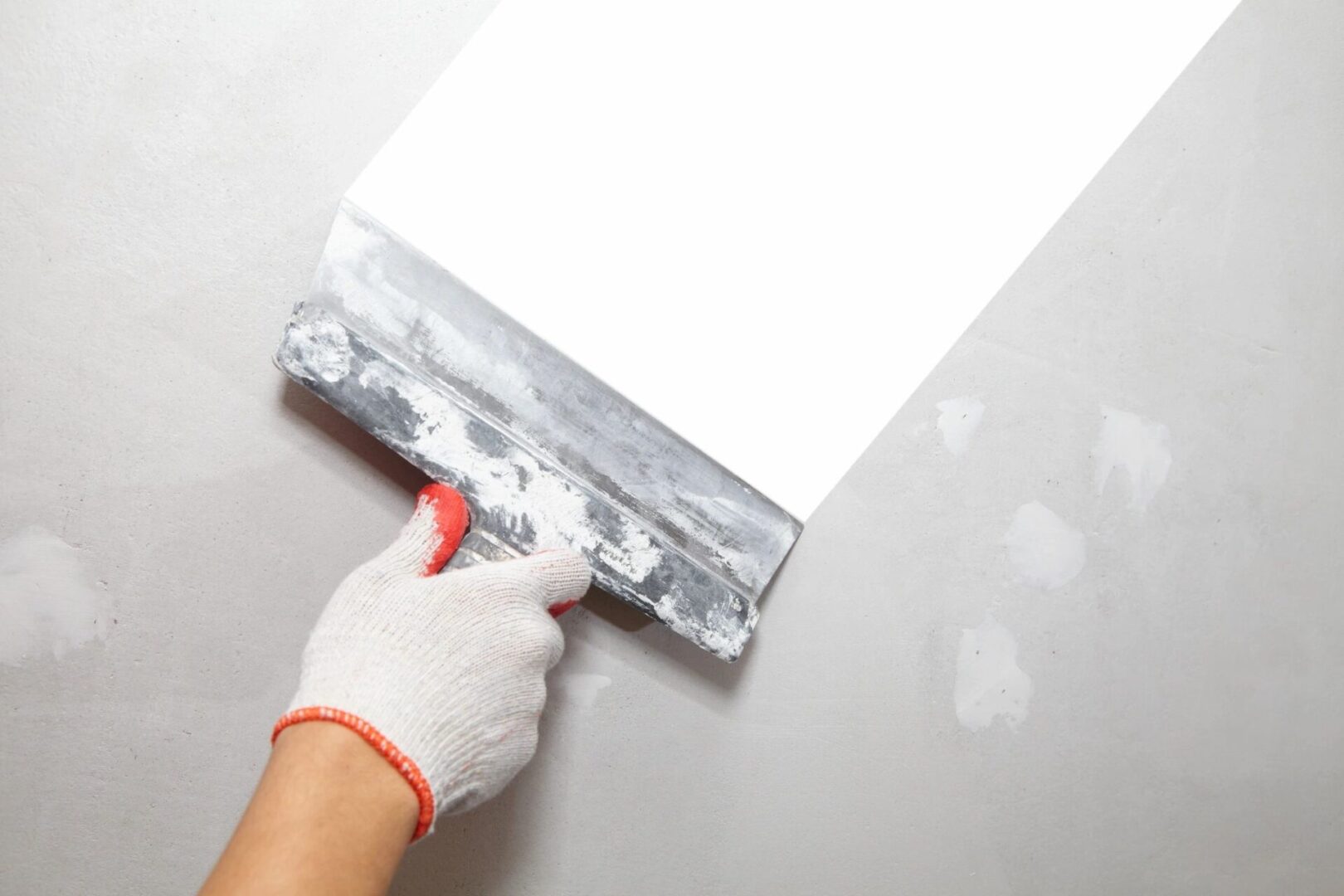 A person in white gloves holding a paint roller.